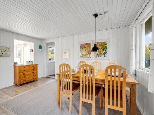 a dining room with a wooden table and chairs at Holiday Home Pirjo - 350m to the fjord by Interhome in Skjern