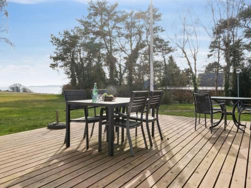einen Tisch und Stühle auf einer Holzterrasse in der Unterkunft Holiday Home Salka - 200m to the inlet by Interhome in Frederiksværk