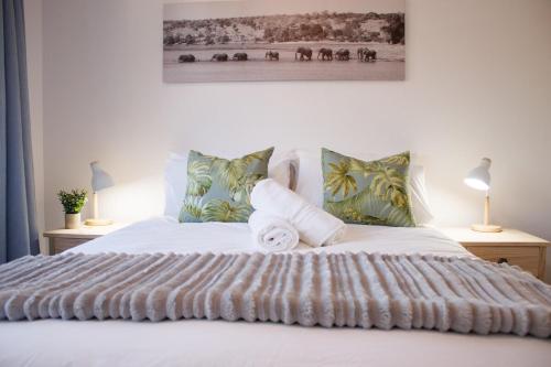 乔治209 Le Jardin George的卧室配有带两盏灯的白色床