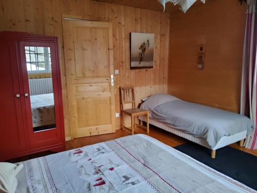 a bedroom with two beds and a red door at Chalet Etch Soulet in Jurvielle