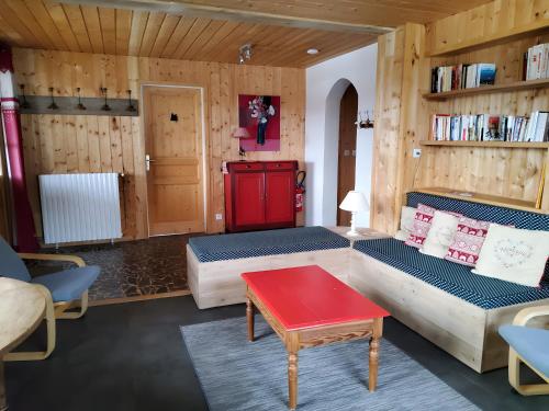 a living room with two couches and a red table at Chalet Etch Soulet in Jurvielle
