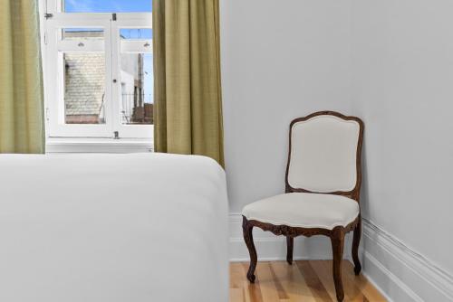 a chair sitting in front of a window at Le Chateau de Pierre in Quebec City