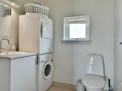 a kitchen with a white refrigerator and a toilet and a sink at Holiday Home Wilmar - 380m from the sea by Interhome in Nabbe