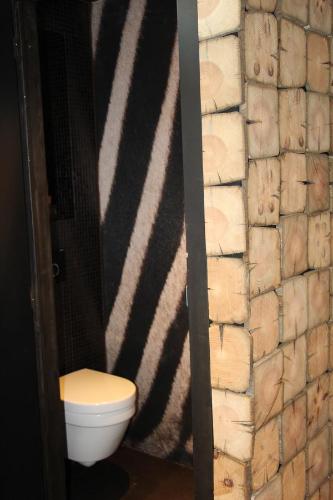 a bathroom with a toilet and a stone wall at Koto Garden Suites in Antwerp