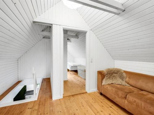 a living room with a couch in a attic at Holiday Home Matilda - 1-6km from the sea by Interhome in Ulfborg