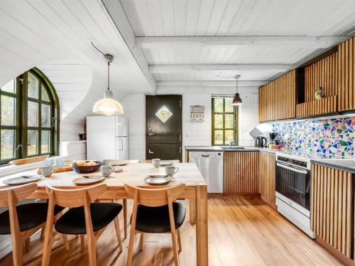 a large kitchen with a wooden table and chairs at Holiday Home Matilda - 1-6km from the sea by Interhome in Ulfborg