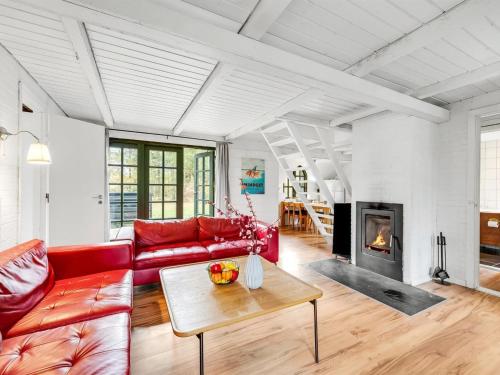a living room with a red couch and a fireplace at Holiday Home Matilda - 1-6km from the sea by Interhome in Ulfborg