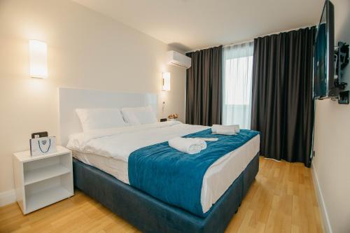 a bedroom with a large bed with a blue blanket at Batumi River Source in Batumi