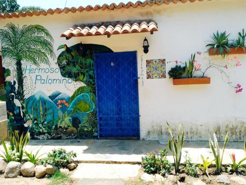 a house with a blue door and a mural at Hermoso Palomino in Palomino
