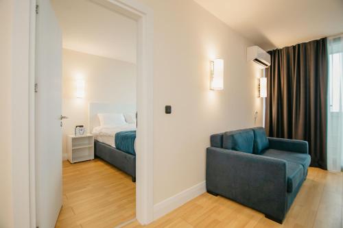 a bedroom with a bed and a couch and a chair at Batumi River Source in Batumi