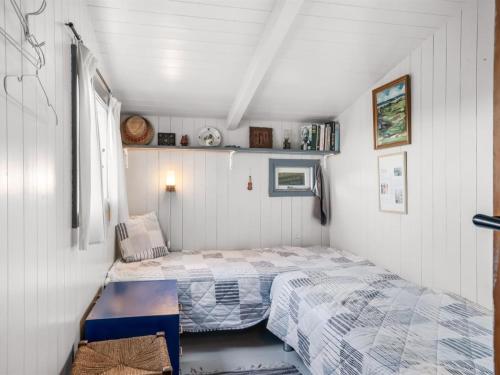 a small bedroom with two beds and a table at Holiday Home Sella - 600m from the sea by Interhome in Blokhus