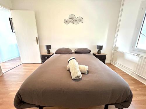 a bedroom with a large bed with two towels on it at Le Valentine, Calme & Lumineux, proche centre in Valence