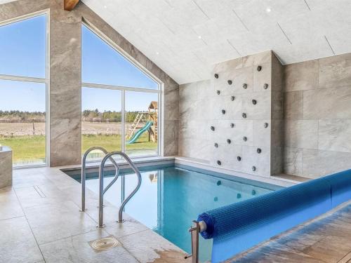 an indoor swimming pool with a slide in a house at Holiday Home Sönke - 4km from the sea by Interhome in Tagholm