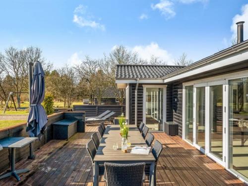 a deck with a table and chairs and an umbrella at Holiday Home Elisaveta - 400m to the fjord by Interhome in Vemb