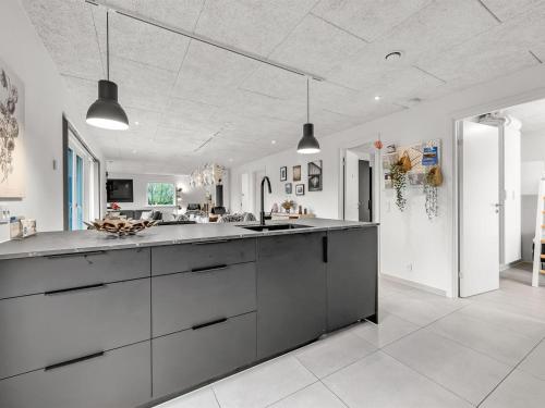 a large white kitchen with a large counter top at Holiday Home Elisaveta - 400m to the fjord by Interhome in Vemb