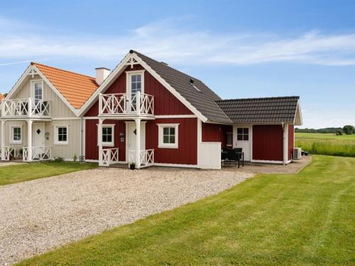 a red and white house with a large yard at Holiday Home Sakari - 375m from the sea by Interhome in Bro