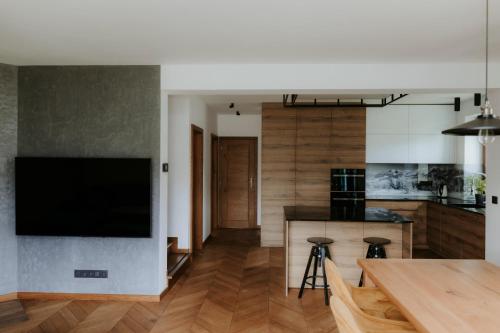 a kitchen with a large flat screen tv on the wall at Chata Stromček in Zuberec
