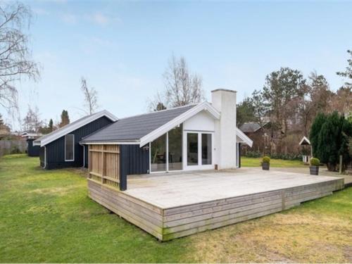 ein Haus mit einer großen Terrasse in einem Garten in der Unterkunft Holiday Home Frithlef - 1-3km from the sea by Interhome in Græsted