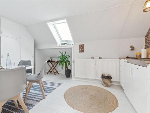 a kitchen with white cabinets and a table and a rug at Apartment Annvy - 1km from the sea by Interhome in Neksø