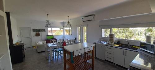 a kitchen with white cabinets and a table and chairs at Casa Bonita - Balneario RETA - alquiler temporario in Reta