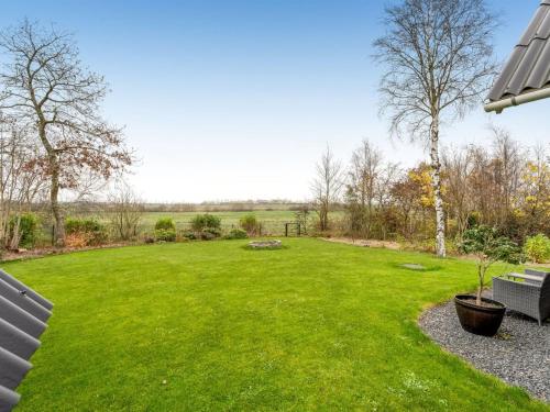 a large yard with a green lawn with two benches at Holiday Home Adisl - 600m to the fjord by Interhome in Løgsted