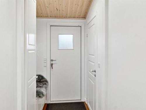 a hallway with a door with a cat sitting in it at Holiday Home Eero - 175m to the inlet by Interhome in Grevinge