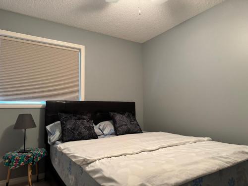 カルガリーにあるCozy Comfort Rooms in SE Calgary, Canadaの窓のある部屋にベッドがある寝室