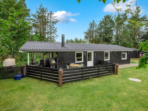 a black and white house with a fence at Holiday Home Tiina - 500m to the fjord by Interhome in Tarm