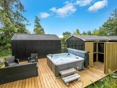 a hot tub on a deck with a black fence at Holiday Home Tiina - 500m to the fjord by Interhome in Tarm