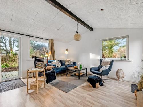 a living room with a blue couch and chairs at Holiday Home Tiina - 500m to the fjord by Interhome in Tarm