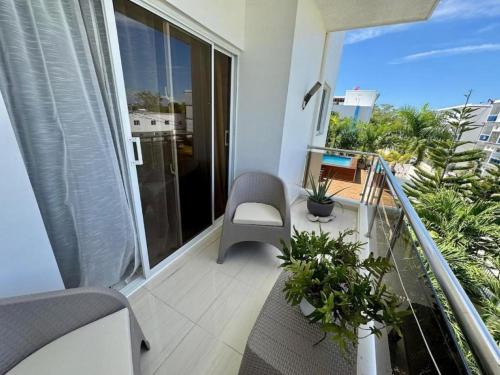 a balcony with a chair and some plants on it at Bayahibe Apartment by the Beach in Bayahibe