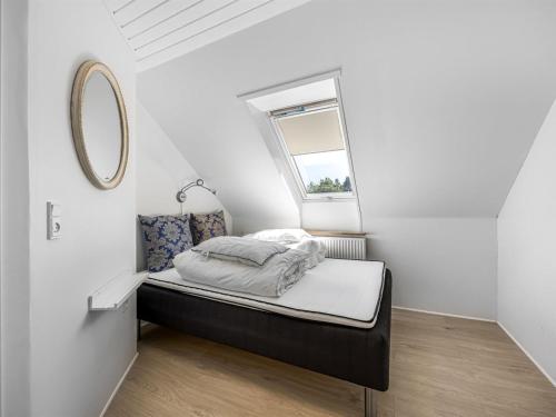 a small bedroom with a bed and a window at Holiday Home Solvey - 400m from the sea by Interhome in Sæby