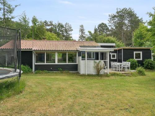 a small black house with a yard and a house at Holiday Home Raika - 1-5km from the sea by Interhome in Tengslemark