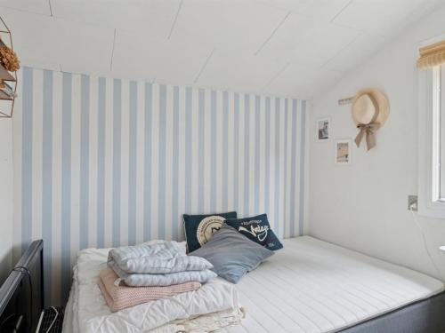 a bed in a room with a striped wall at Holiday Home Raika - 1-5km from the sea by Interhome in Tengslemark