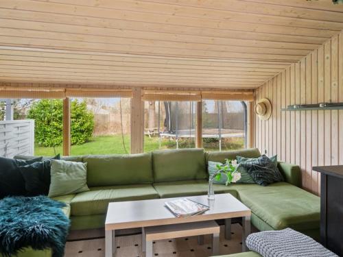 a living room with a green couch and a table at Holiday Home Raika - 1-5km from the sea by Interhome in Tengslemark