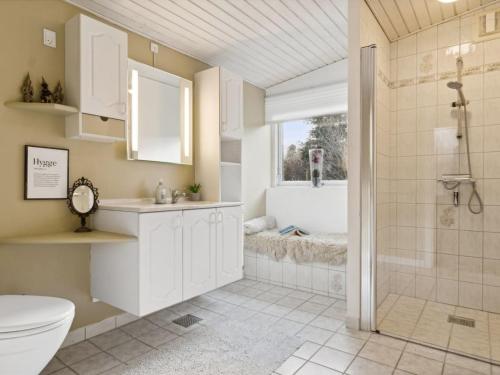 a bathroom with a shower and a toilet and a tub at Holiday Home Elemine - 300m to the fjord by Interhome in Kirke-Hyllinge