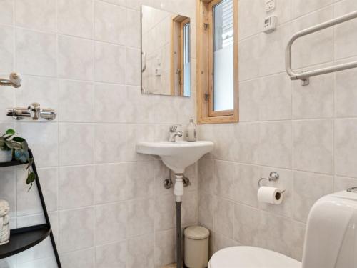 a bathroom with a sink and a toilet and a mirror at Holiday Home Elemine - 300m to the fjord by Interhome in Kirke-Hyllinge