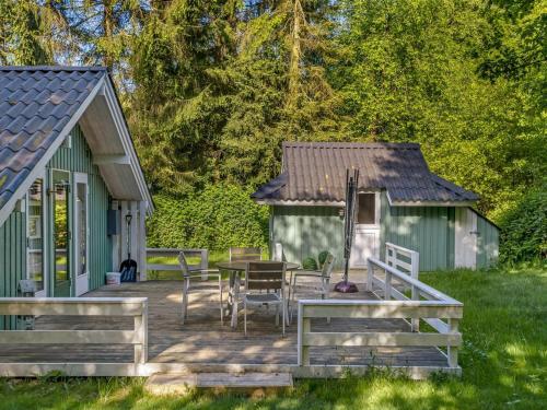 a green shed with a table and chairs on a deck at Holiday Home Ung - 30km from the sea by Interhome in Toftlund