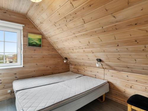 a bedroom with a bed in a wooden wall at Holiday Home Romy - 450m from the sea by Interhome in Bagenkop