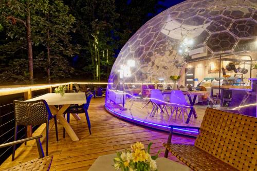 a igloo on a deck at night with tables and chairs at 1 of a kind! Largest Transparent Luxe Dome in USA! in Forks of Ivy