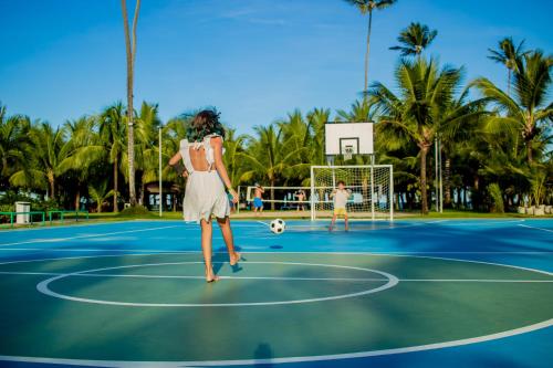 a woman is playing soccer on a tennis court at Vivá Porto de Galinhas Resort in Porto De Galinhas