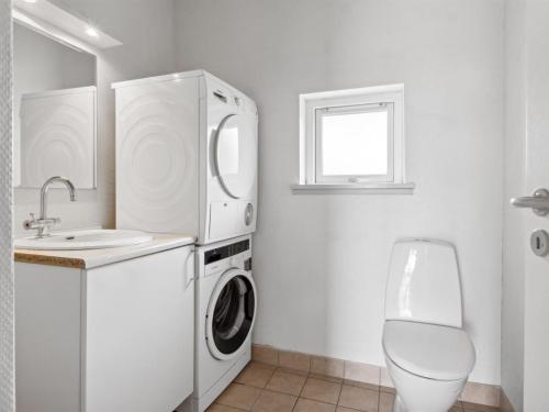 a white bathroom with a washing machine and a sink at Holiday Home Gudbrand - 500m from the sea by Interhome in Bogentved