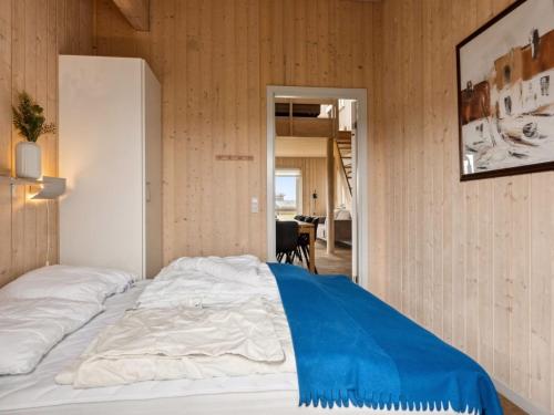 a bedroom with a bed with a blue blanket at Holiday Home Gudbrand - 500m from the sea by Interhome in Bogentved