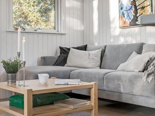 a living room with a gray couch and a wooden coffee table at Holiday Home Baldo - 800m from the sea by Interhome in Blokhus