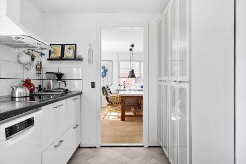 a kitchen with white appliances and a dining room at 70268-Ulfborg-Vesterhavsgade-16 in Thorsminde