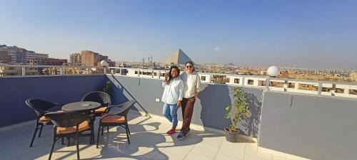 two people standing on top of a balcony at Phoenix Pyramids View Inn in Cairo