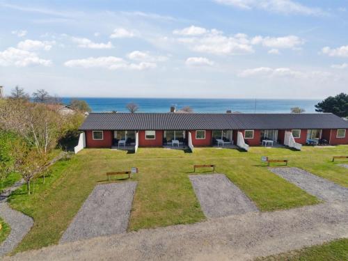 a red building with benches and the ocean in the background at Apartment Kate - 300m from the sea by Interhome in Allinge