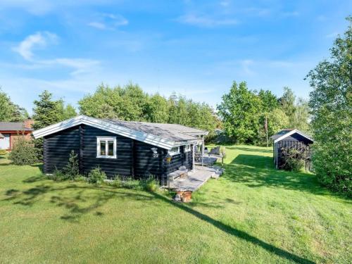 a cabin in the middle of a grass field at Holiday Home Bengta - 500m from the sea by Interhome in Gedser