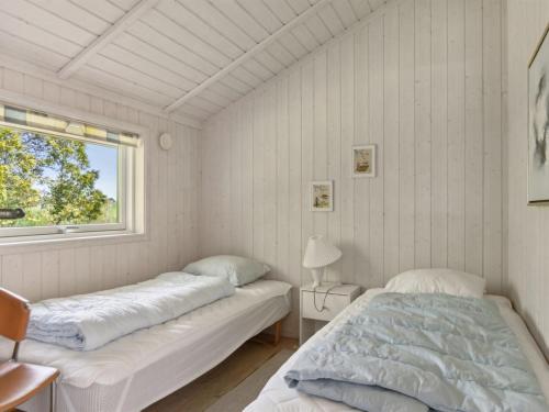 two beds in a room with a window at Holiday Home Hjalmine - 225m from the sea by Interhome in Gørlev