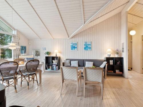 a living room with a couch and a table and chairs at Holiday Home Hjalmine - 225m from the sea by Interhome in Gørlev
